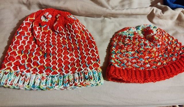 Two King of all hats in reversed colours on bedding