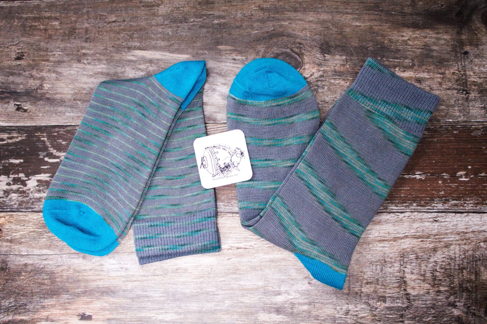 two pairs of socks with spiraling flashes of sea green blues