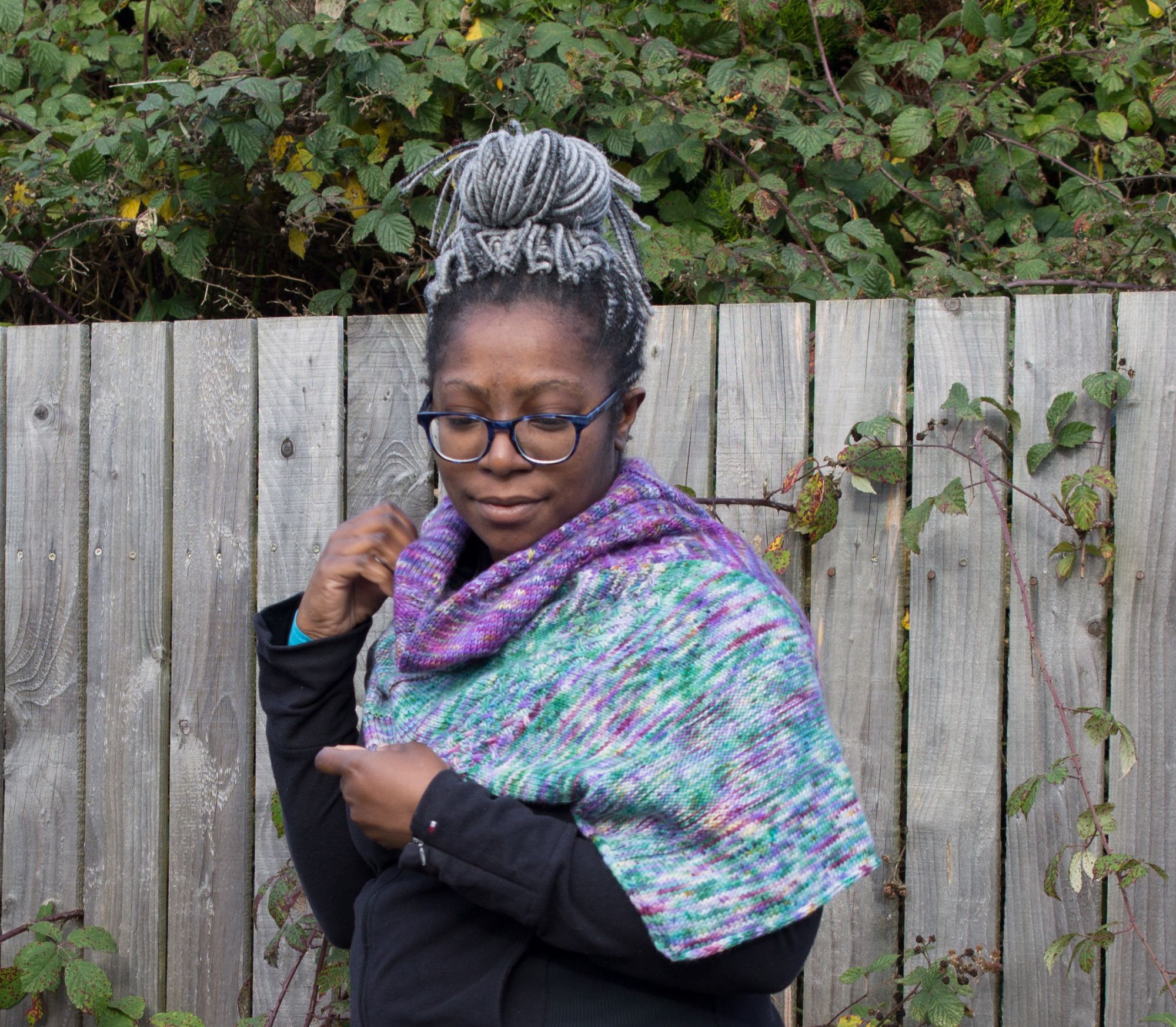 picture of black person side ways on wearing the glasgow shawl wrapped around their shoulders