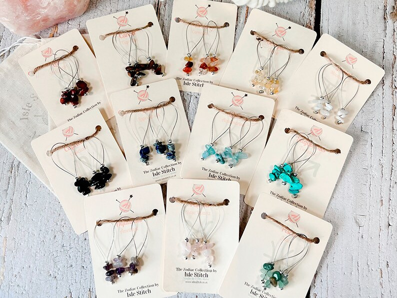 Several sets of birthstone stitchmarkers arranged on individual cards