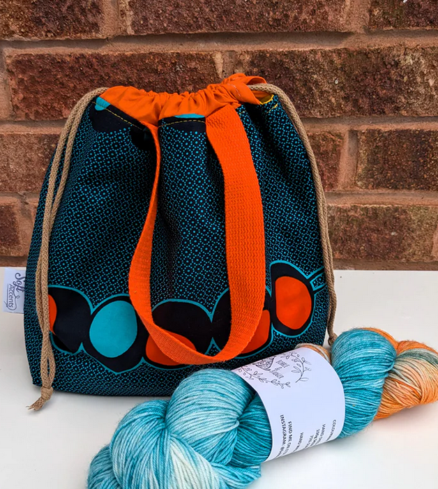 A farai project bag in teals and bright orange