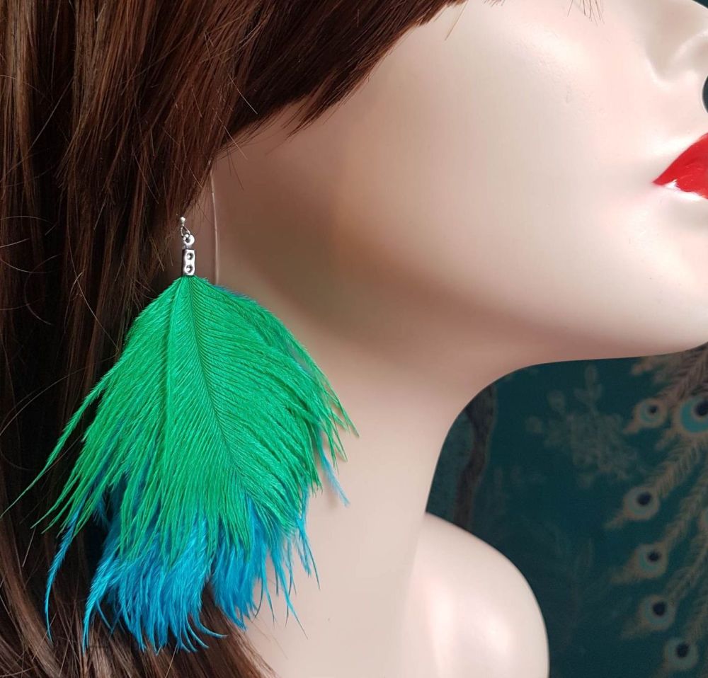 Aqua Blue and Green Ostrich Feather Earrings hangs from the models ear lobe