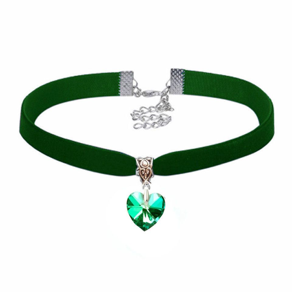 Close‑up of a person wearing a dark green velvet choker with a silver‑tone 