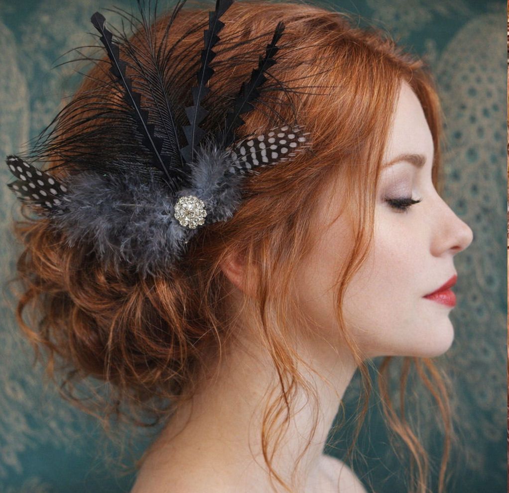 woman with auburn hair styled in a loose updo wears a vintage-inspired blac