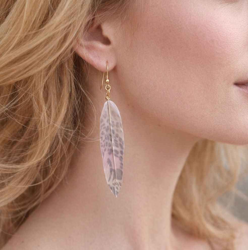 blonde woman wearing leopard print feather earrings