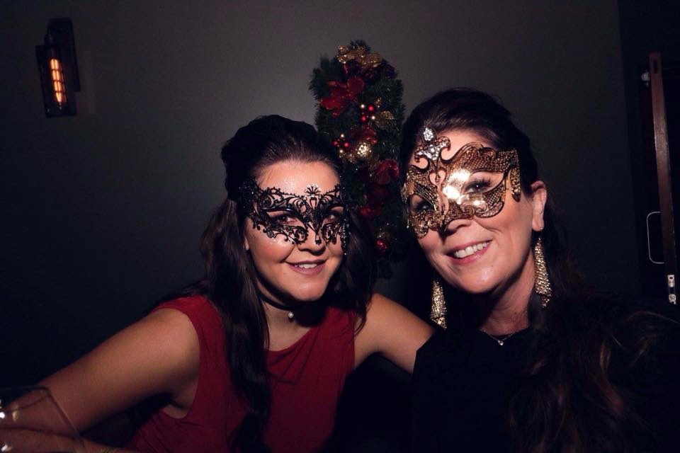  image of two women customers at a masquerade ball