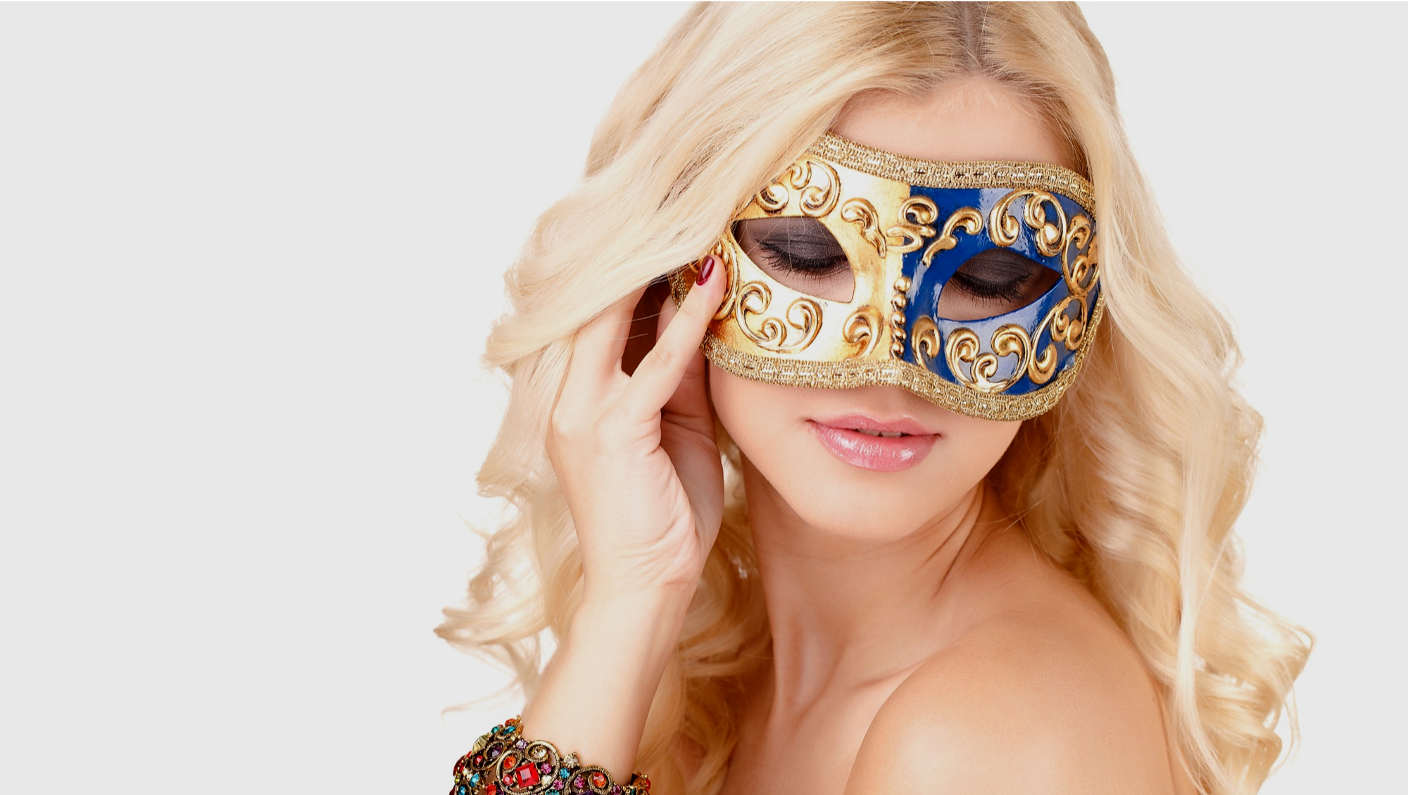 beautiful blonde woman wearing a stunning blue and gold coloured venetian mask