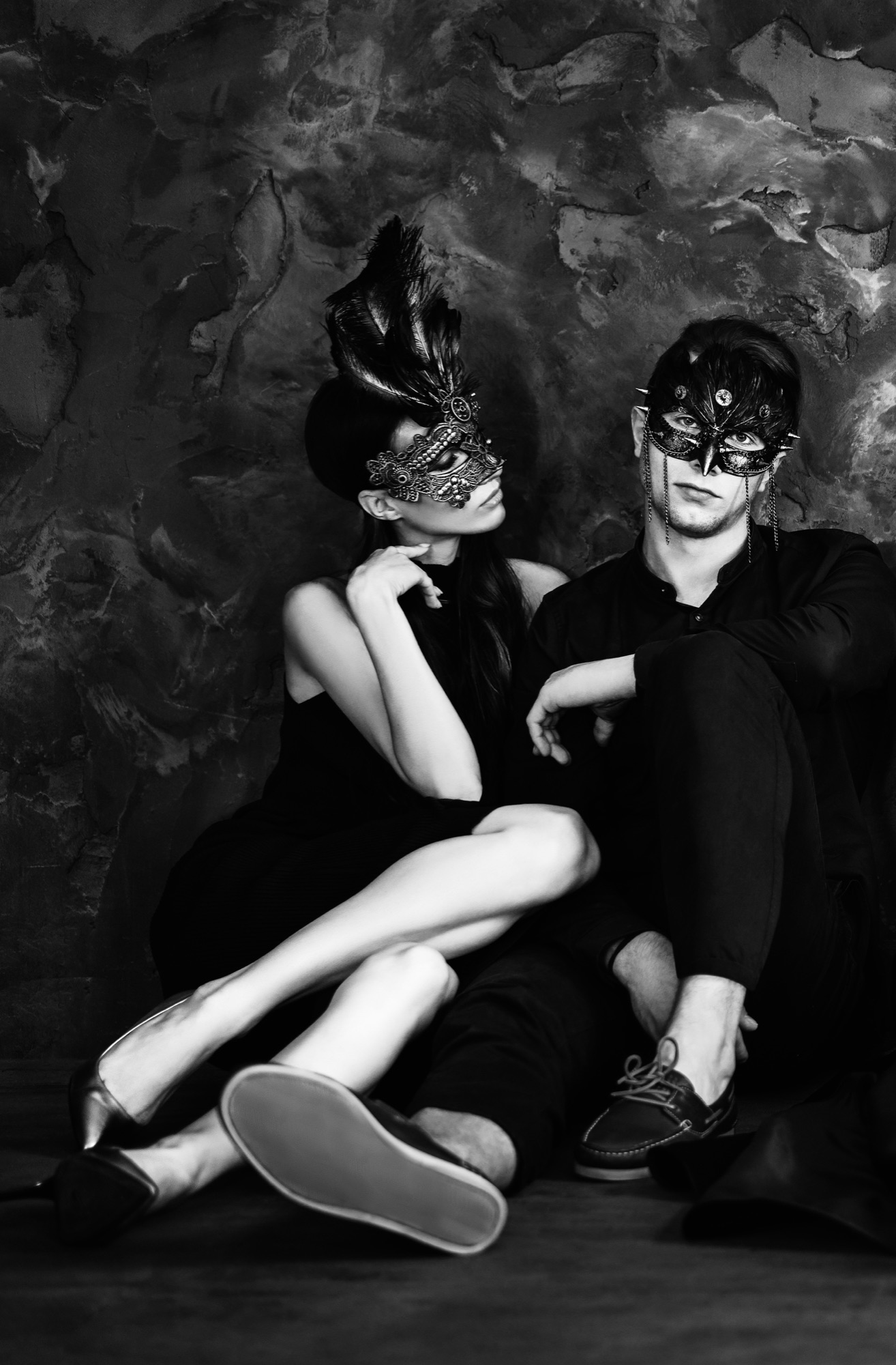 young couple sitting on the floor wearing masquerade masks