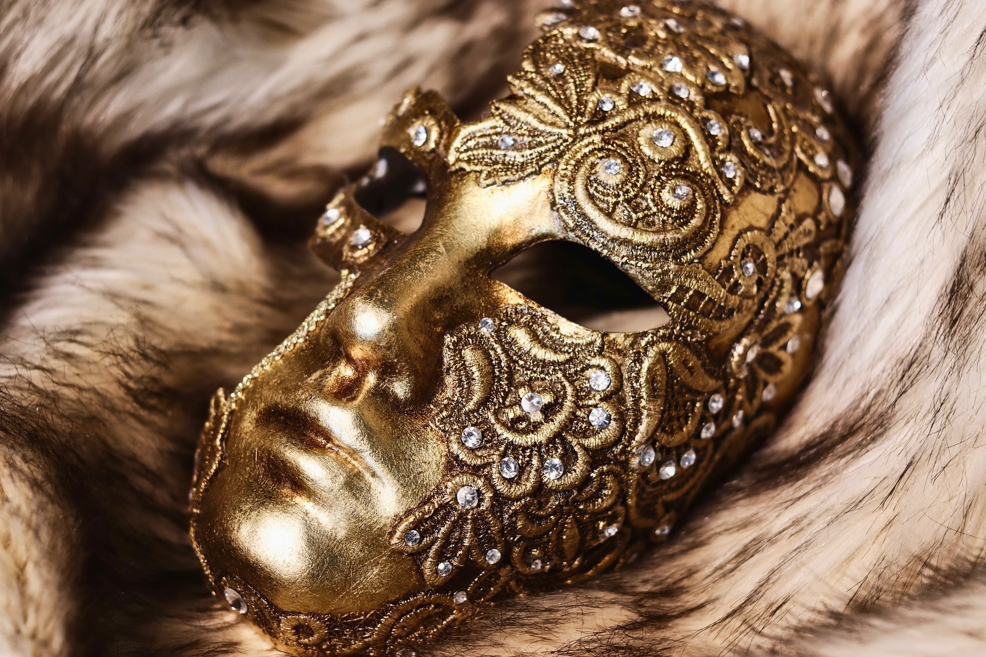 Gold full face masquerade mask on a fur rug