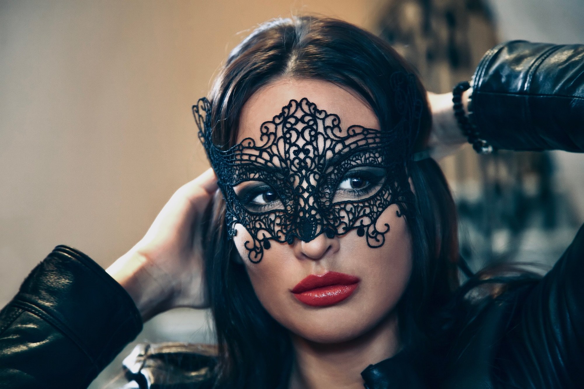 Attractive women with a square face shape trying on a black lace mask