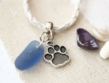 Blue sea glass and a paw print