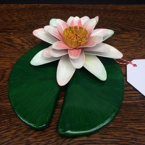 White and pink metal water lily on a leaf pad