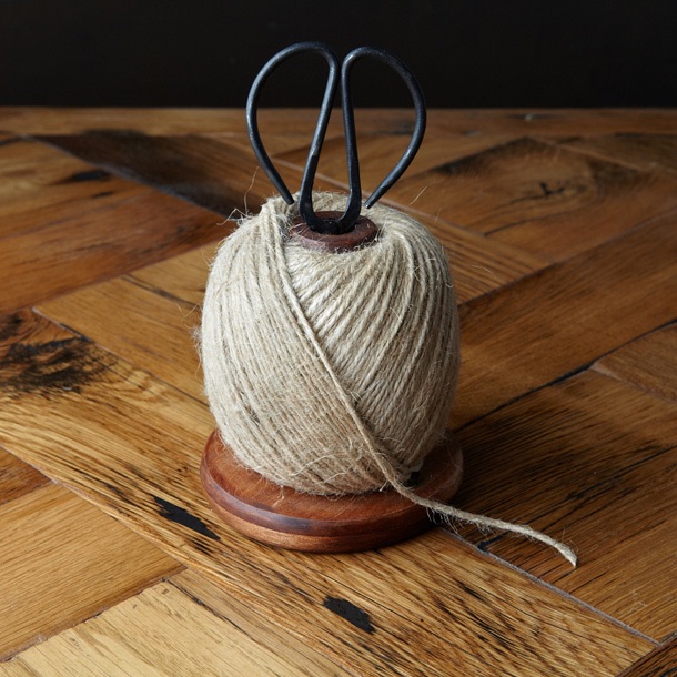 Twine with scissors sitting on a reclaimed wooden bobbin 