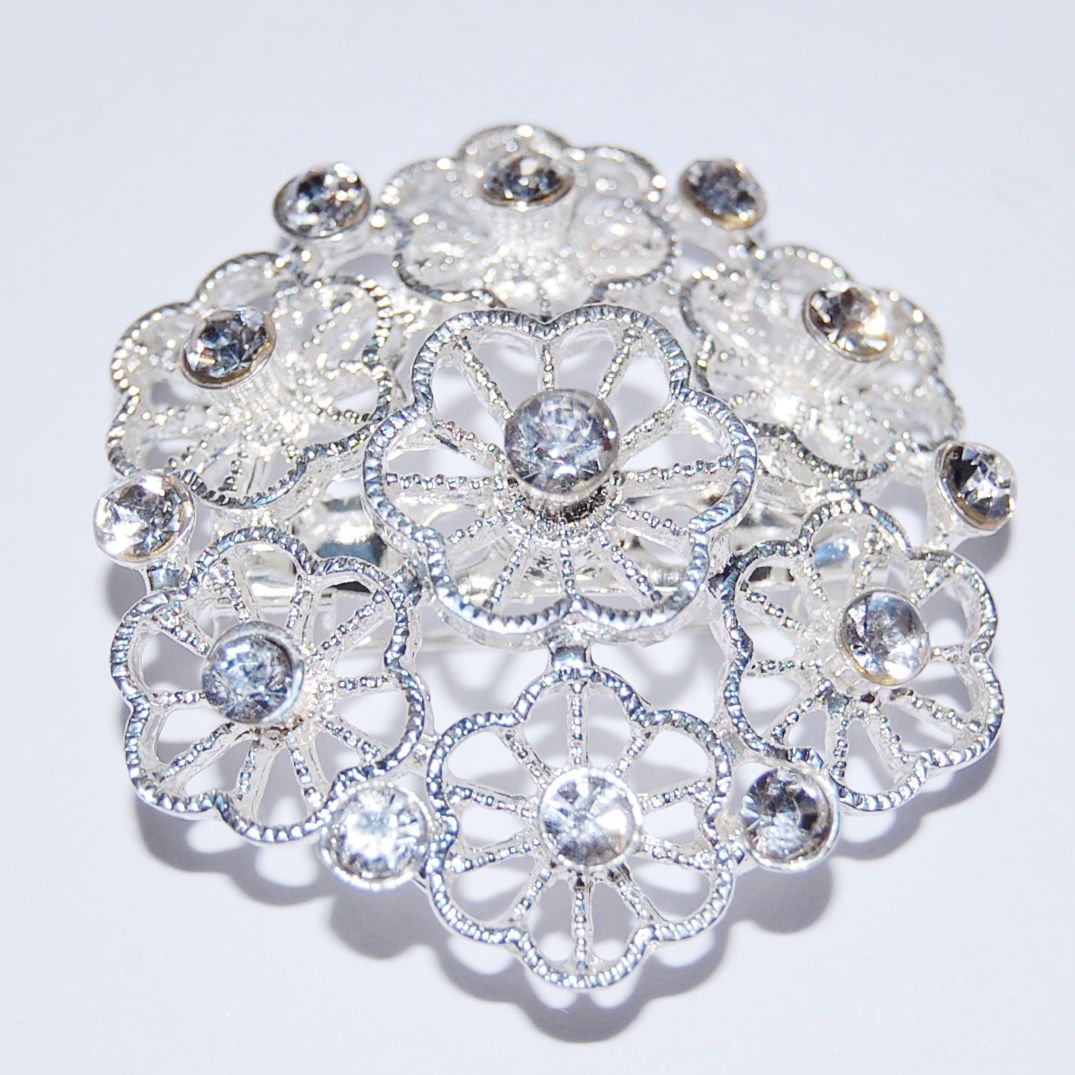 SILVER METAL AND JEWELLED FLOWER BROOCH.