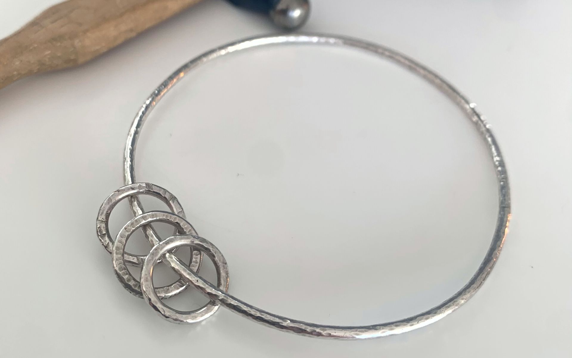 image of a silver bangle with circular charms