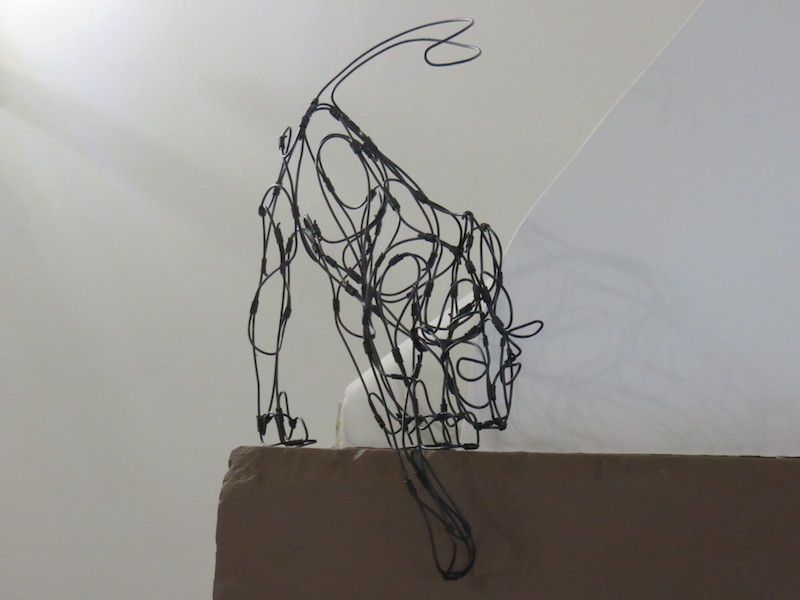 wire cat on fireplace shelf