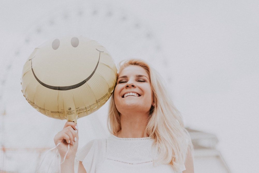 woman-holding-a-smiley-balloon-1236678