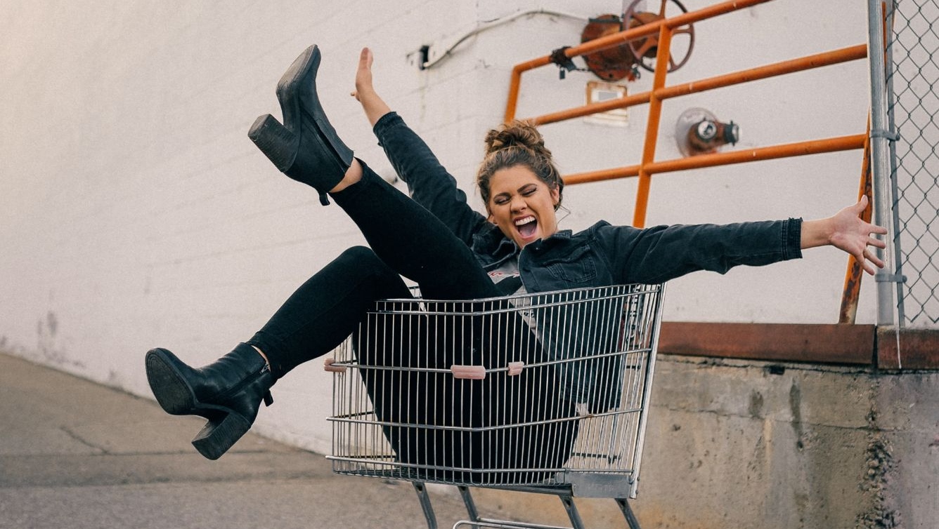 Lady in a shopping trolly looking very happy