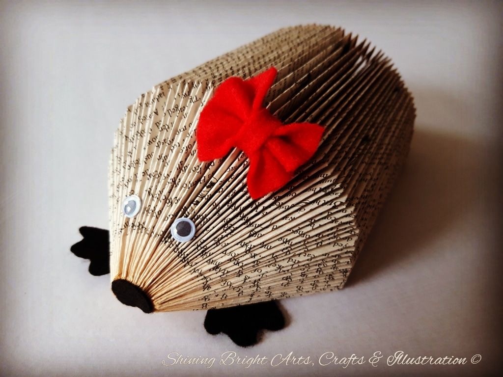 Paper Folded Hedgehog using an old book and decorated with a red bow, eyes, nose and feet