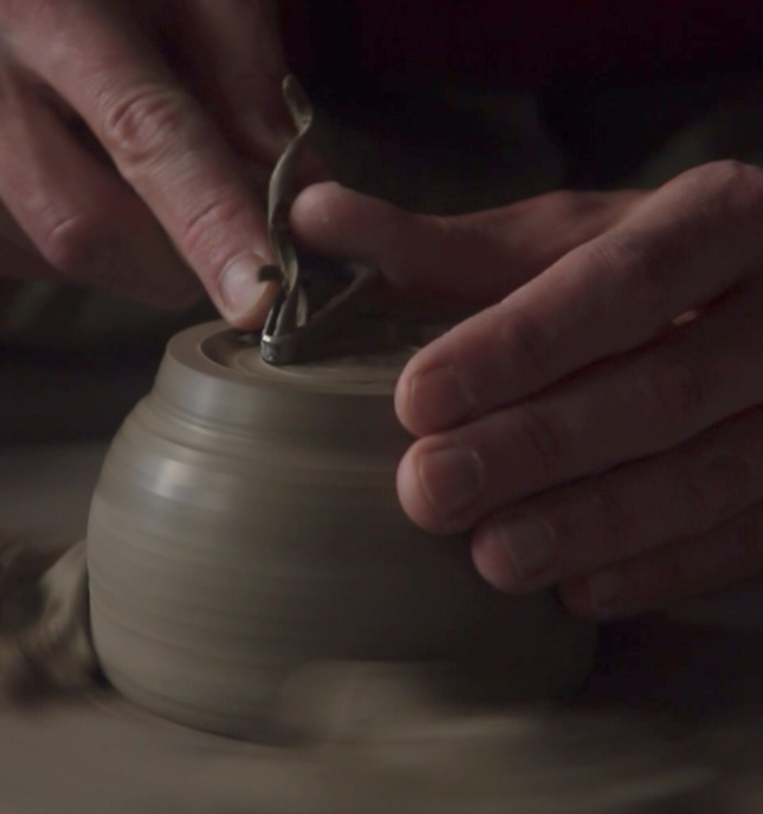 Hands trimming a ceramic bowl