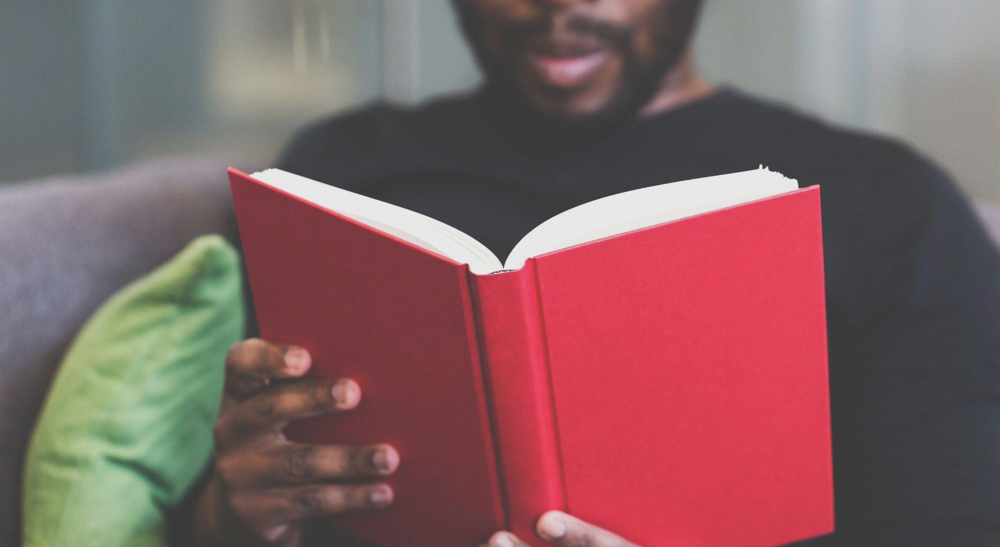 What? - A man, out of focus,  reading a red book