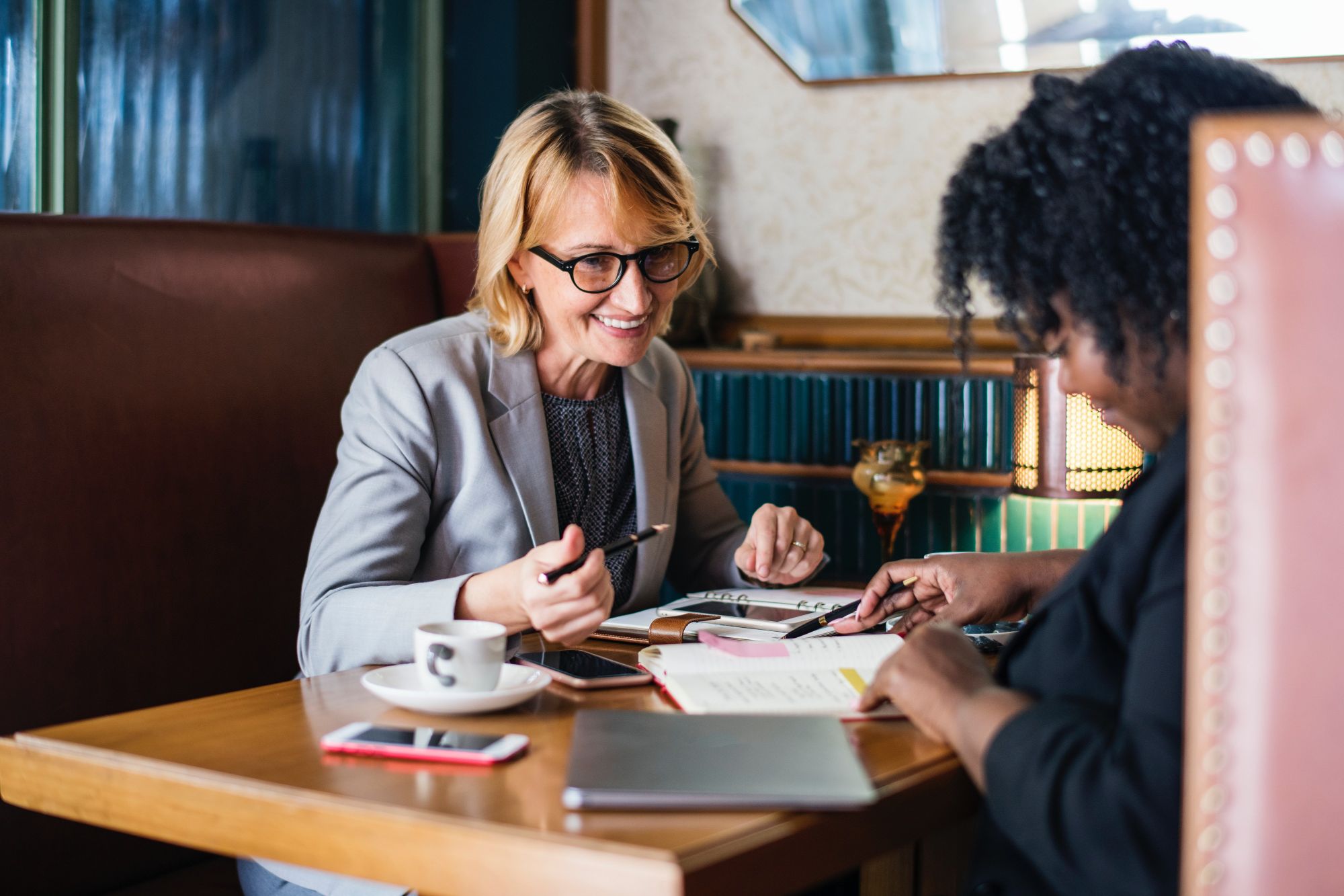 Two woman having a meeting comparing diaries