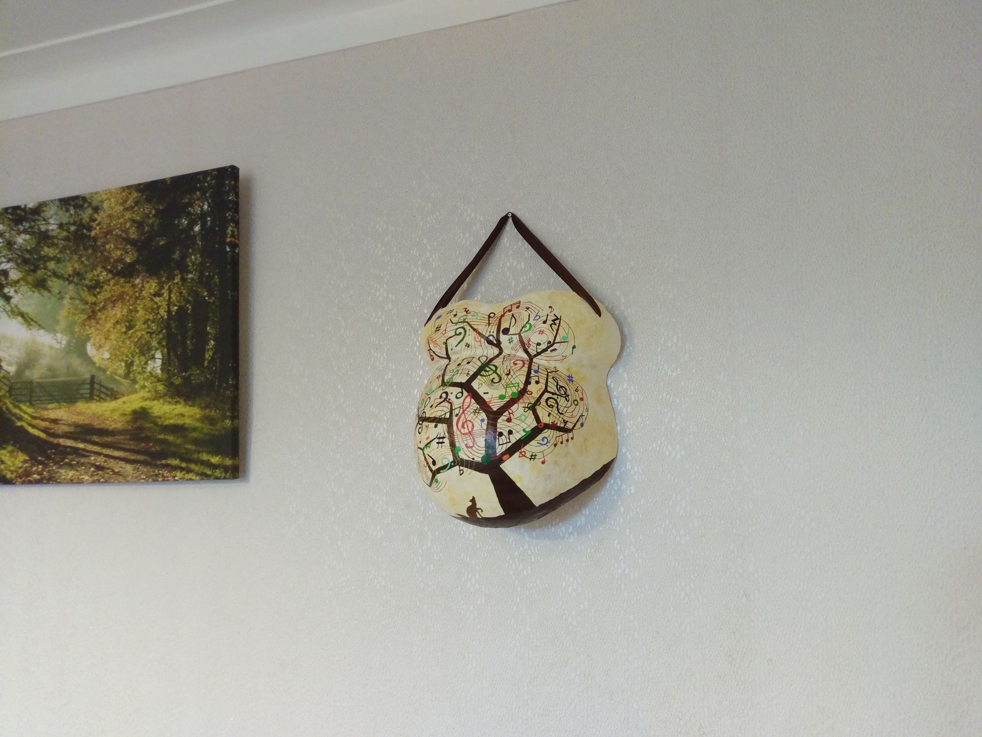 Image of a painted belly cast hanging on a wall.