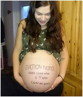 A woman standing with her large pregnancy belly visible. Written on her bump it says: "EVICTION NOTICE Please leave within 1 week, calmly and quickly."