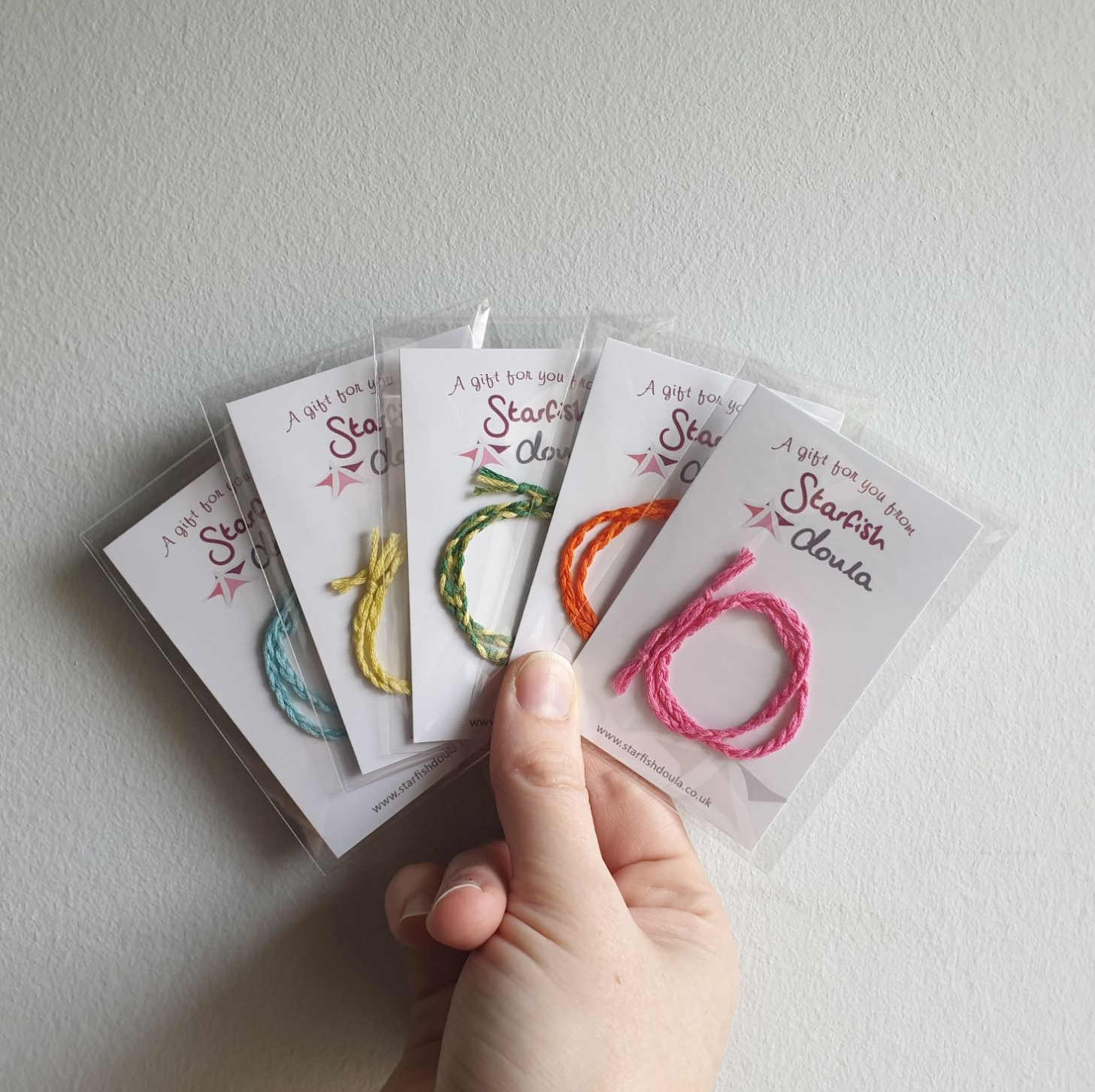 5 differently coloured cord ties in packets.