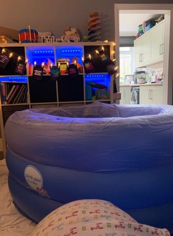 A mini pool in a client's living room. There is a kallax unit behind it draped with fairy lights, and the kitchen is visible through the open doorway next to the unit.