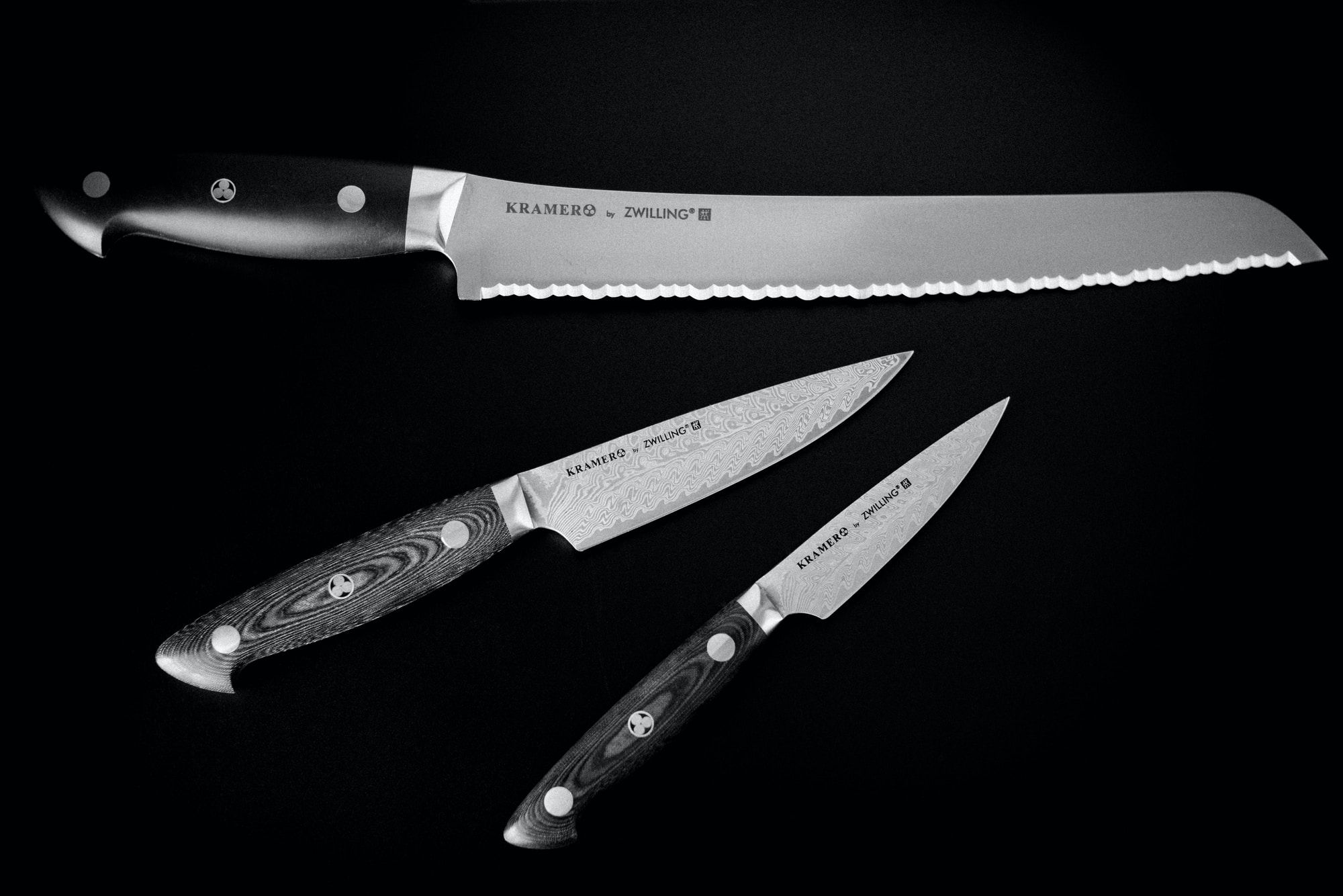 3 kitchen knives of varying sizes displayed on a black background.