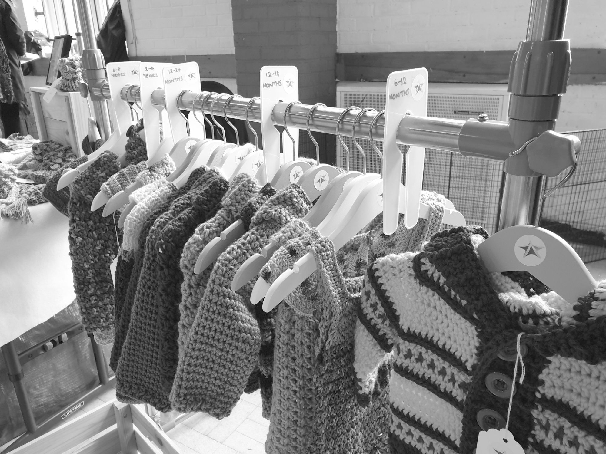 A clothes rail full of crocheted clothes.