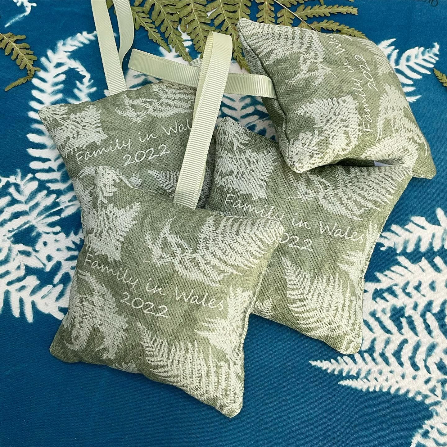 4 lavender bags made from green fabric with a fern print. The bag has 'Family in Wales 2022' printed on it.