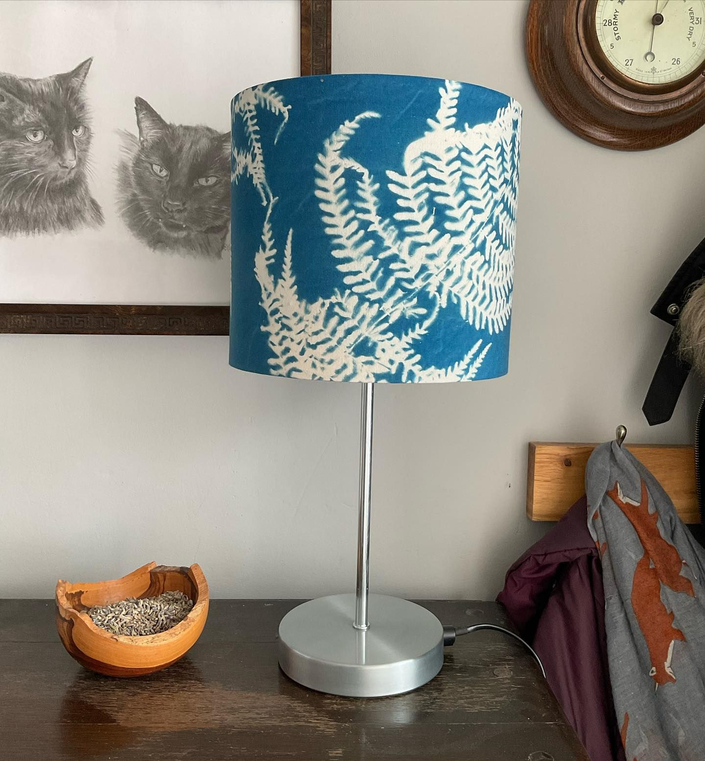 A 20cm drum lampshade is a side board. The lampshade is blue with a fern print.