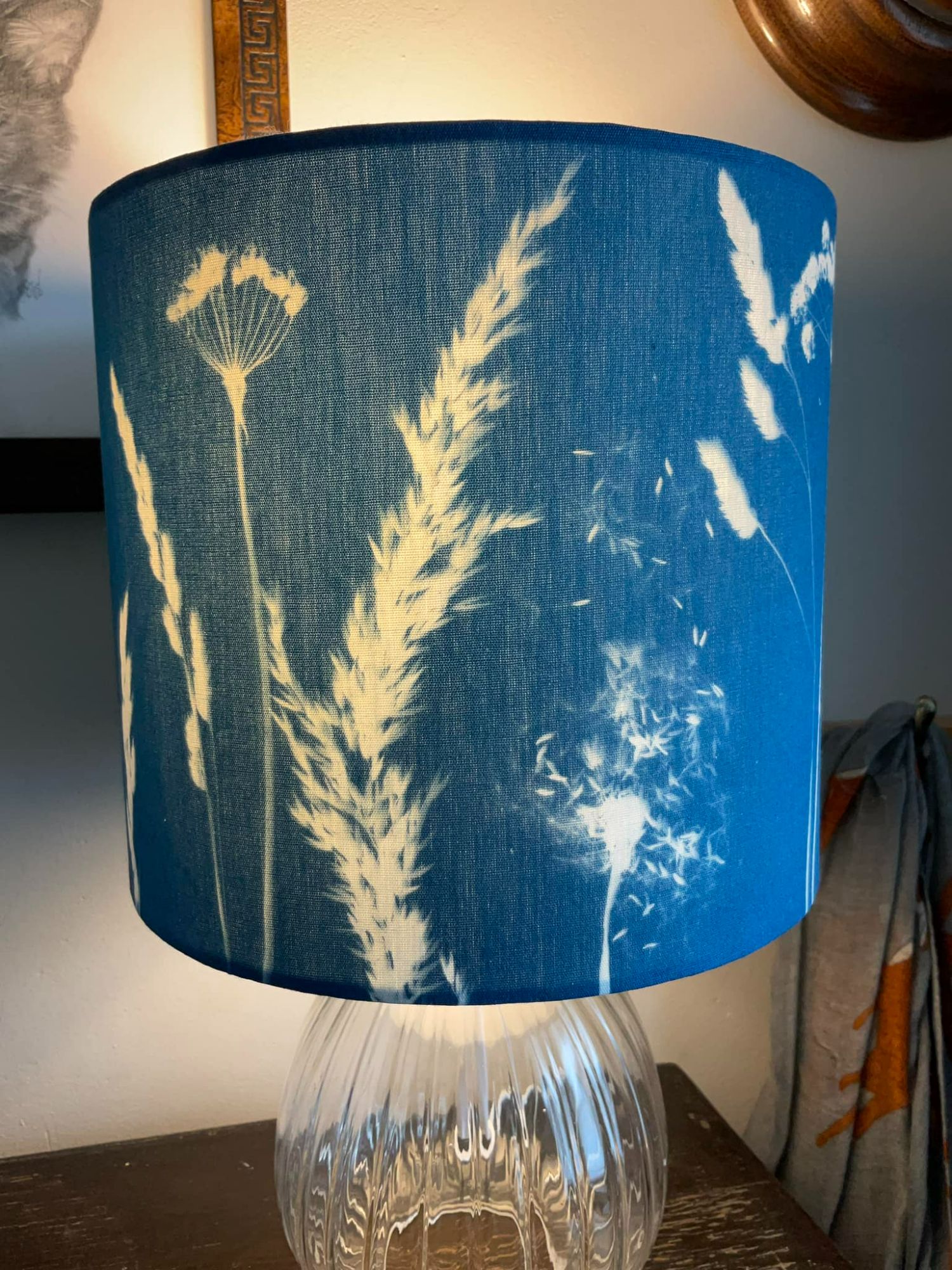 A blue cyanotype lampshade showing dandelions and grasses