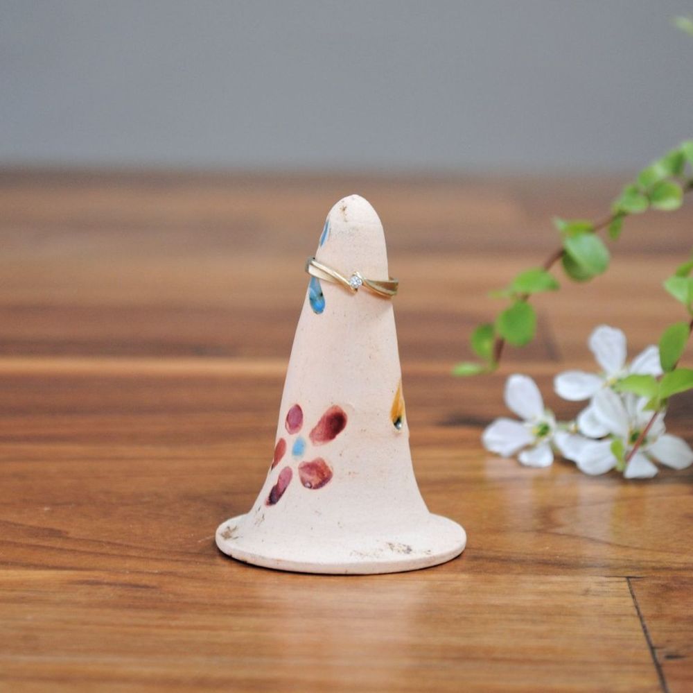 Handmade ceramic ring holder made from white clay, decorated with flowers.