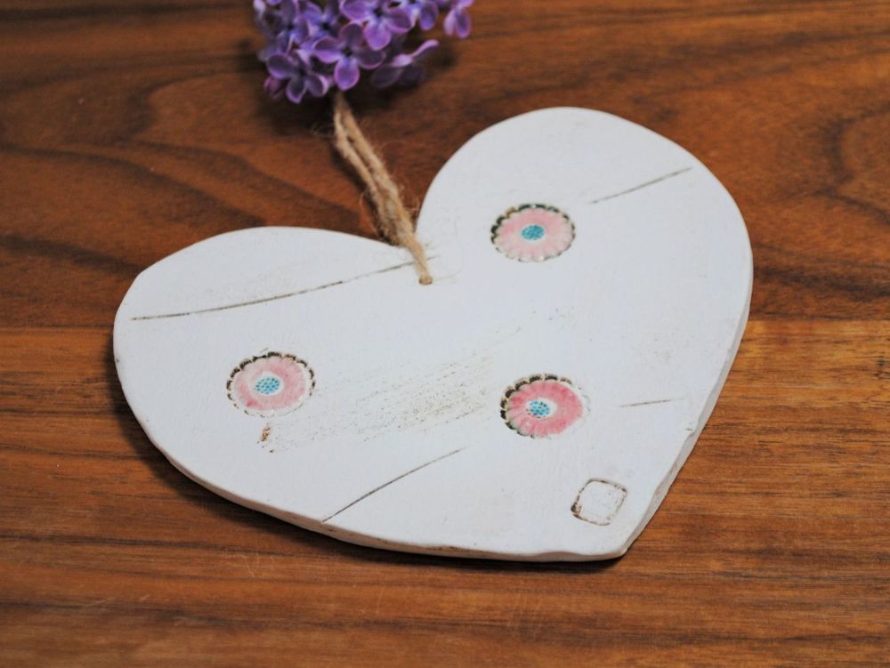 Handmade ceramic hanging heart from white clay with pink/blue flowers detai