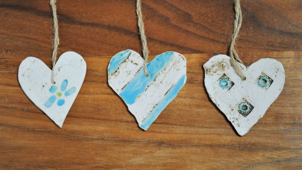 Set of 3 hanging little hearts handmade from a white clay and decorated wit