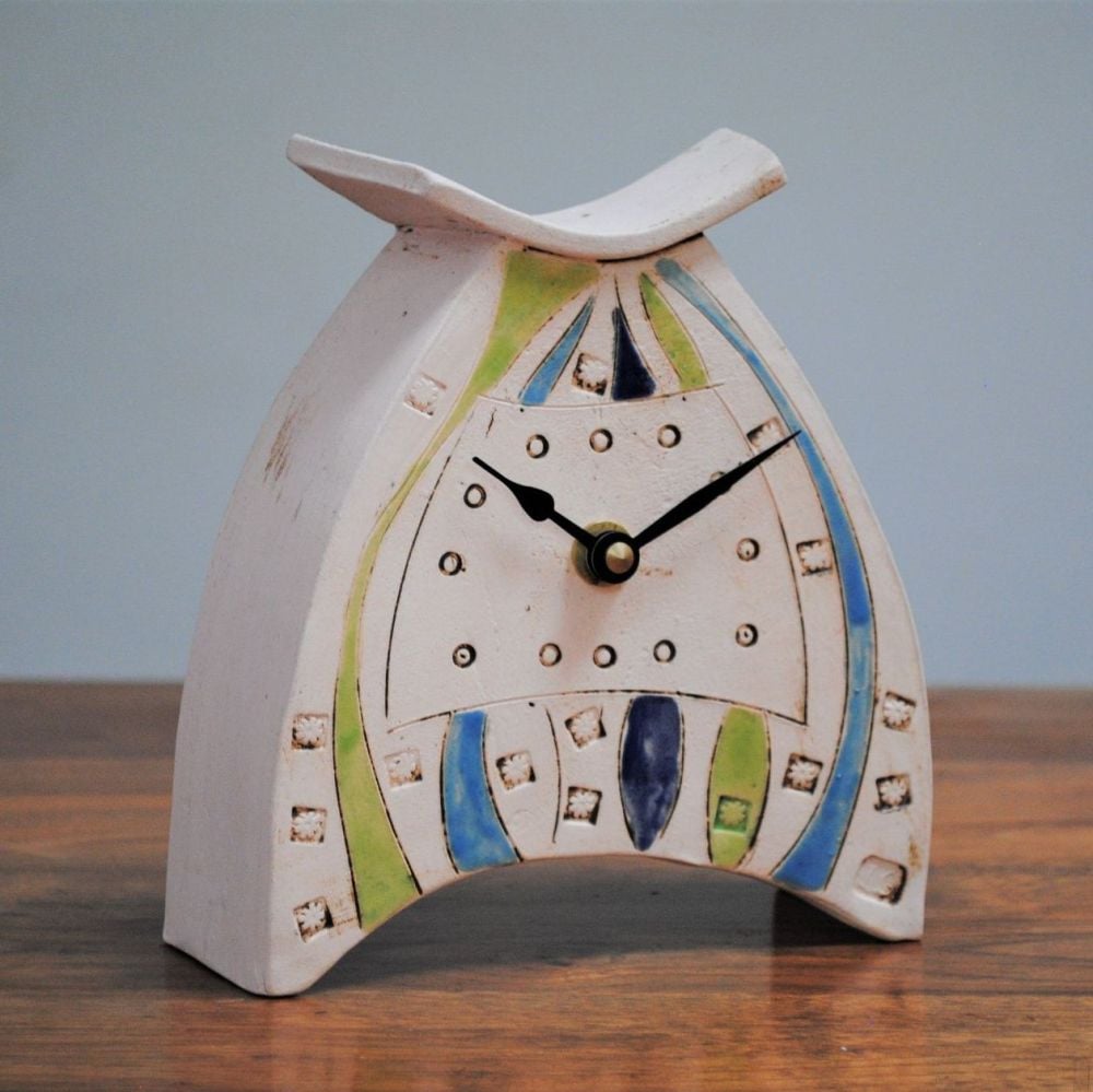 Ceramic handmade clock form white clay with blue and green stripe design.