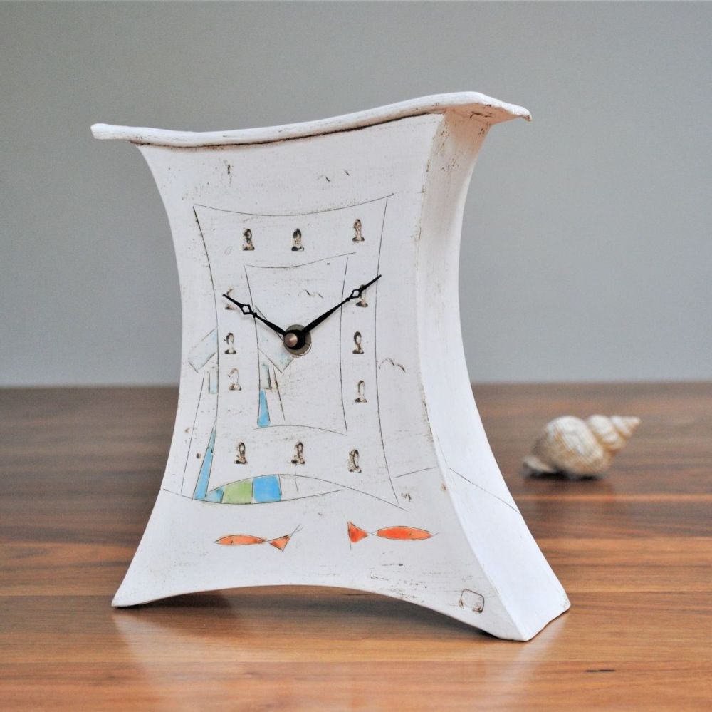 Handmade ceramic nautical clock with beachhuts and fish.