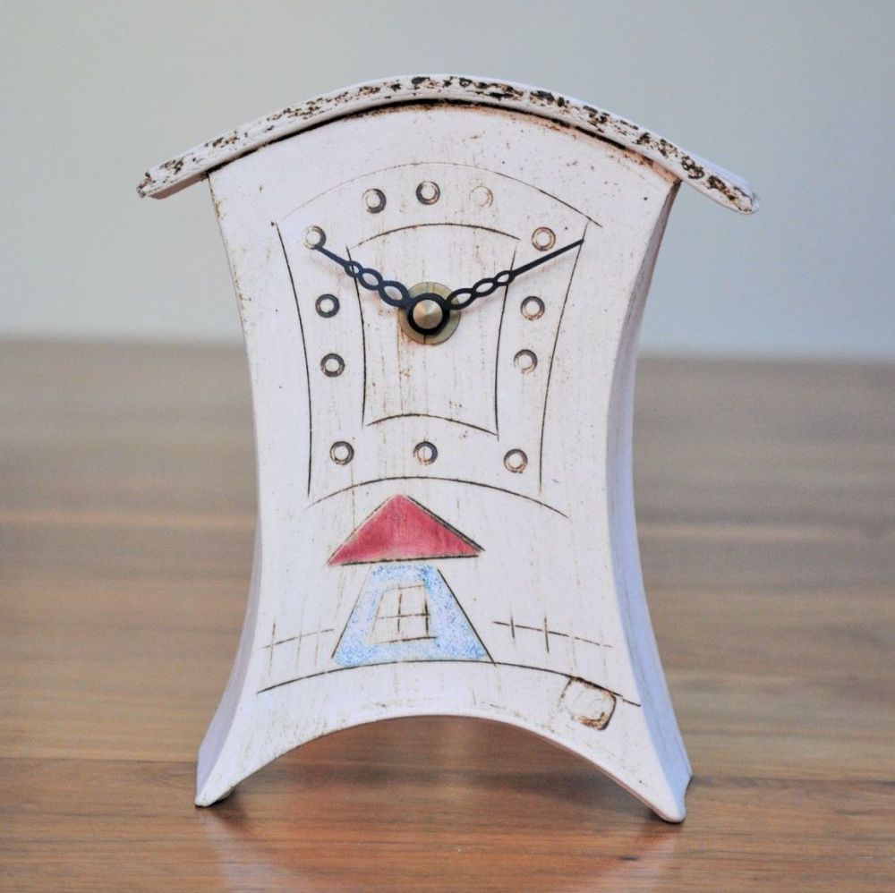 Handmade mantek clock with house design on the clock face.