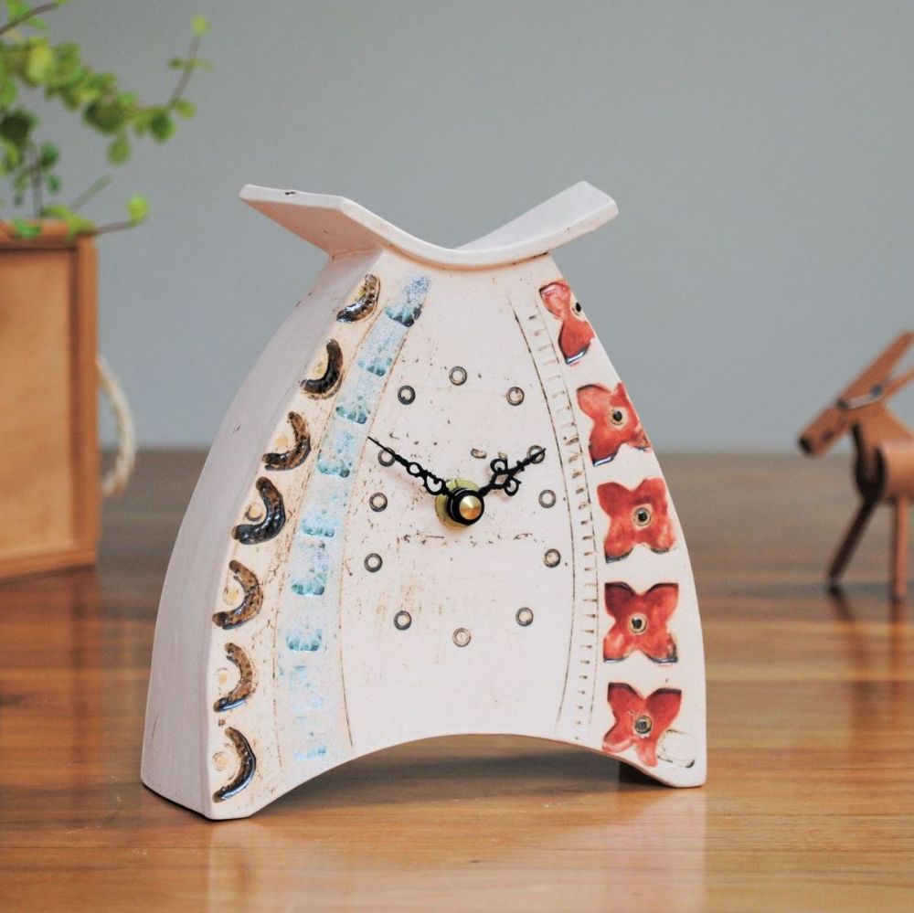Ceramic clock made from white clay and decorated with red, white, metlaic c