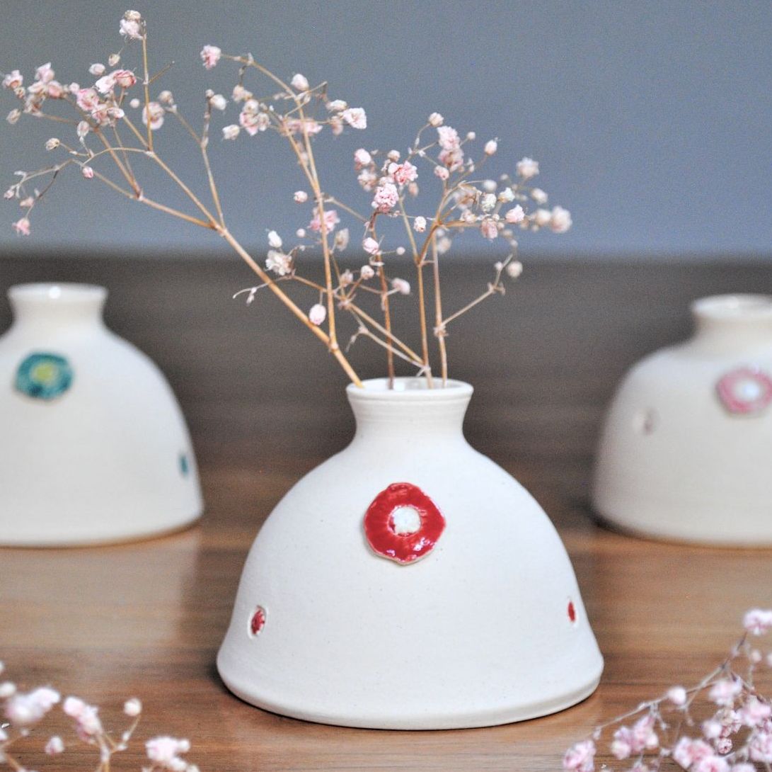 White bud vase with red details.