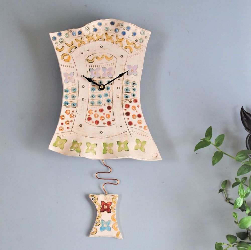 Ceramic pendulum wall clock in rainbow colours.