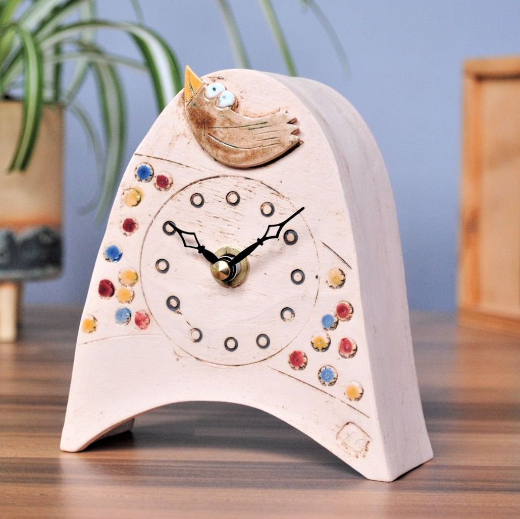 Handamde clock with bird and meadow.