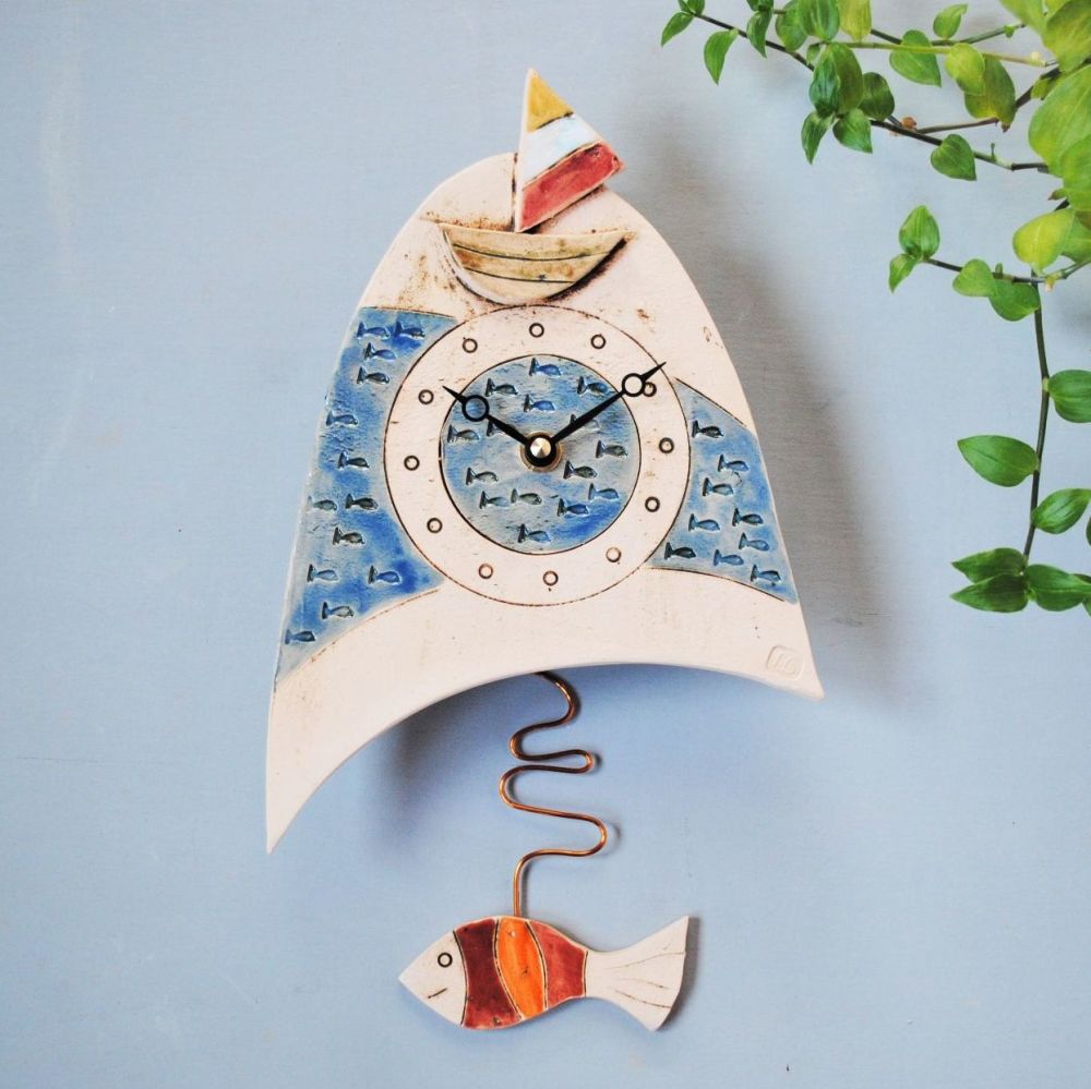 Ceramic wall clock with boat and fish.