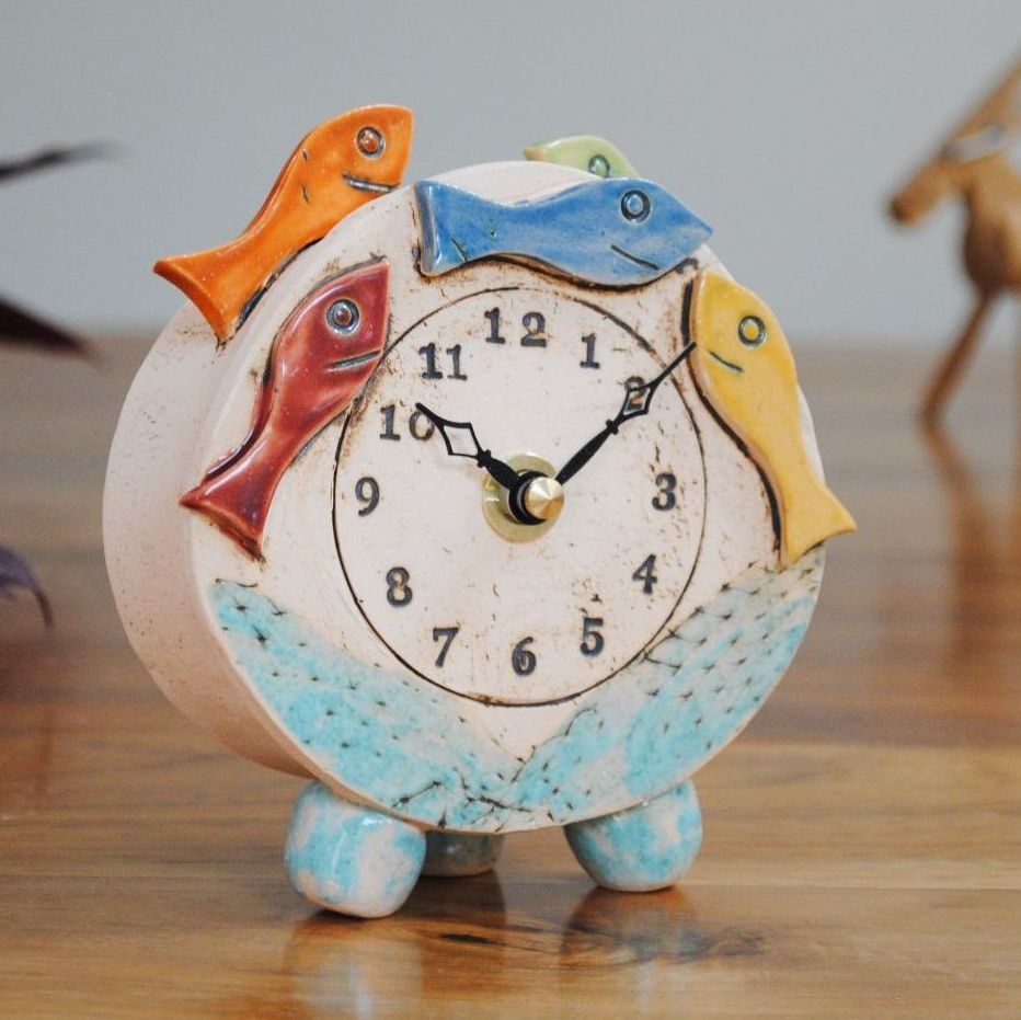 Ceramic clock with colourful fish and blue pebble feet.