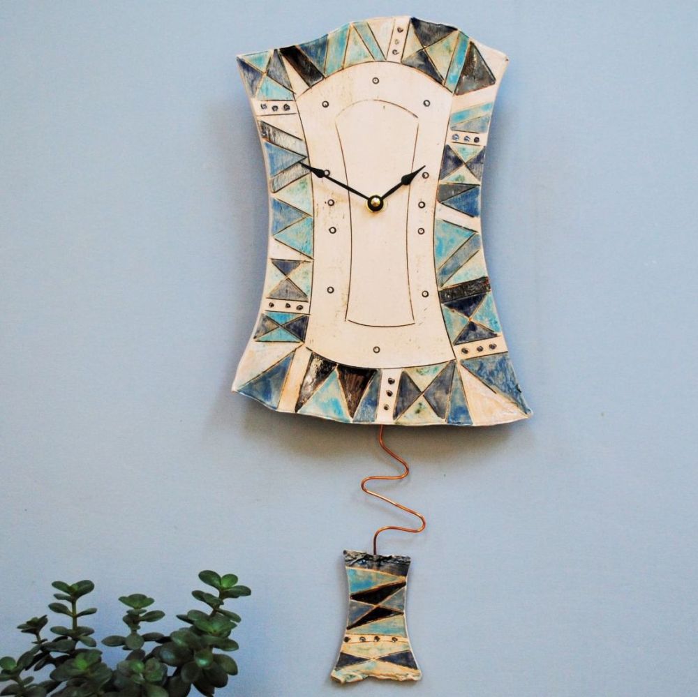 Ceramic pendulum wall clock with blue pattern. 