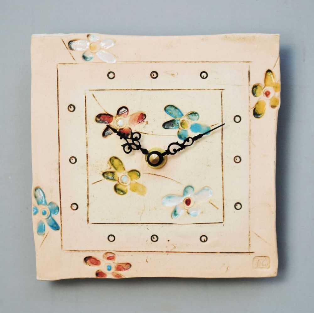 Small tile wall clock with bright flower design.