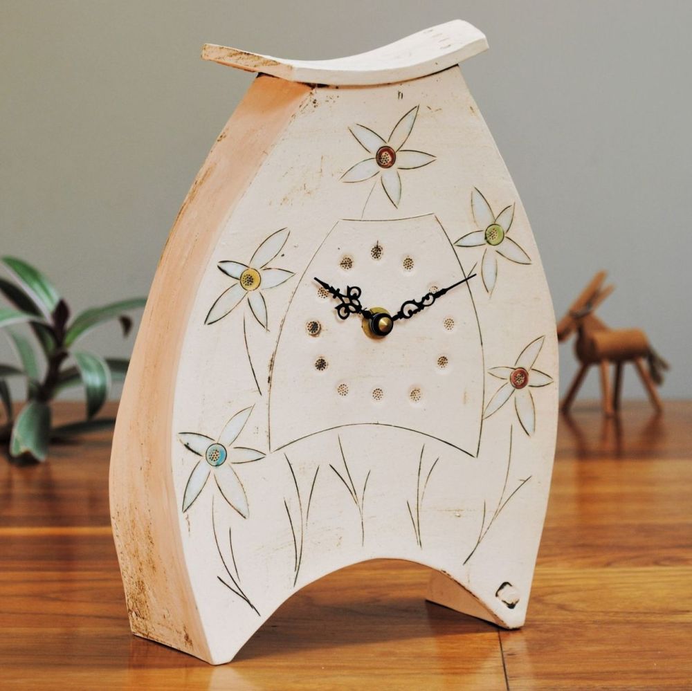 Large off-white mantel clock with flowers.